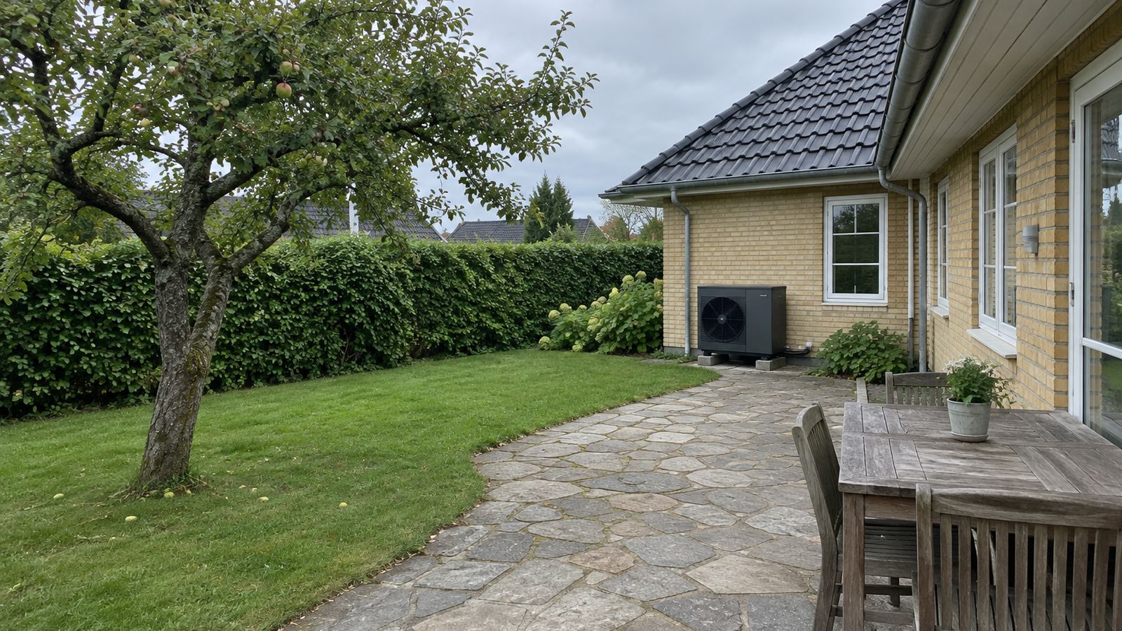 Ny fliseterrasse i aftenlys bag en dansk bolig
